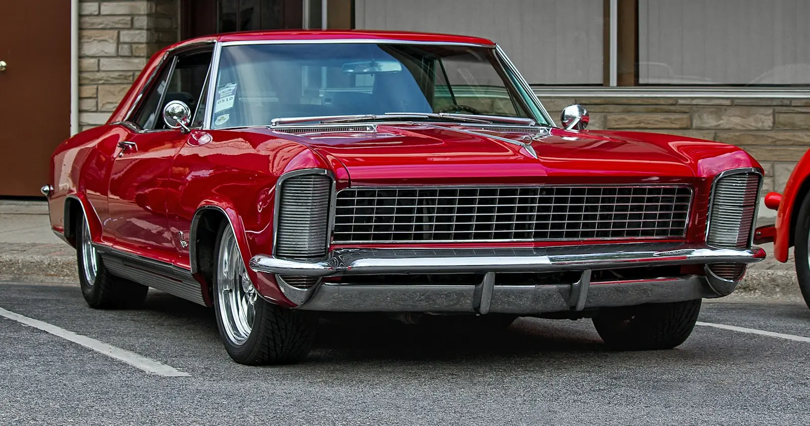 A red American classic from the 1960s in a car park