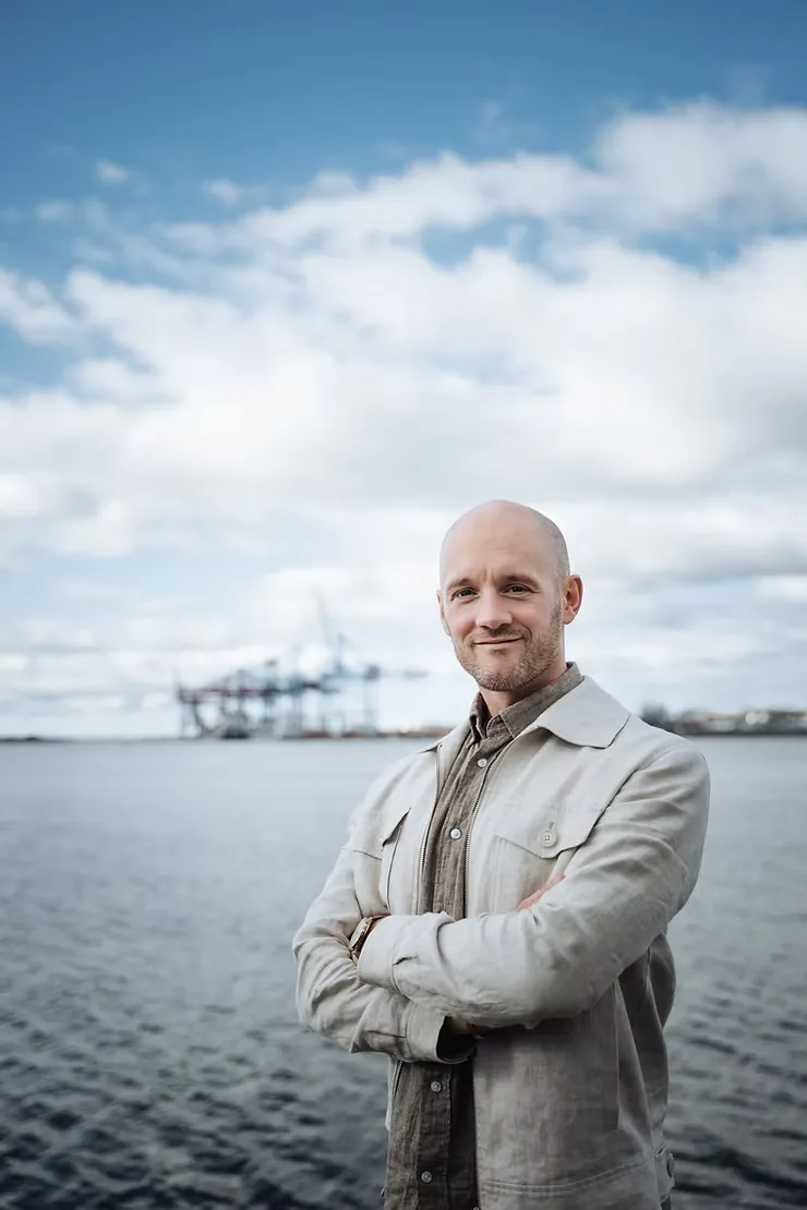 Richard Coster, en av Tullifys grundare, vid kajen med containerkranar i hamnen i bakgrunden