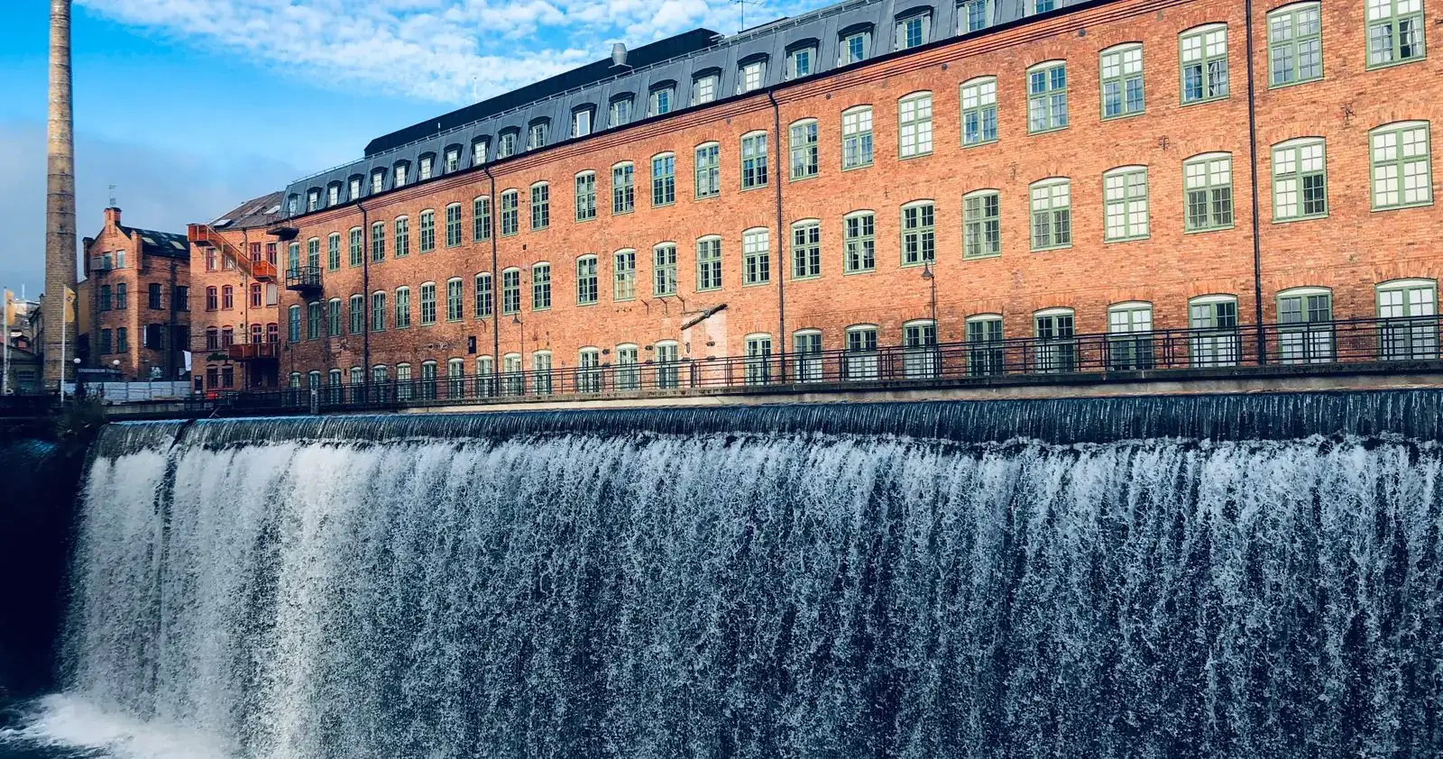 Fabriksbyggnad i tegel vid fallet i Motala ström, i Norrköpings industrilandskap